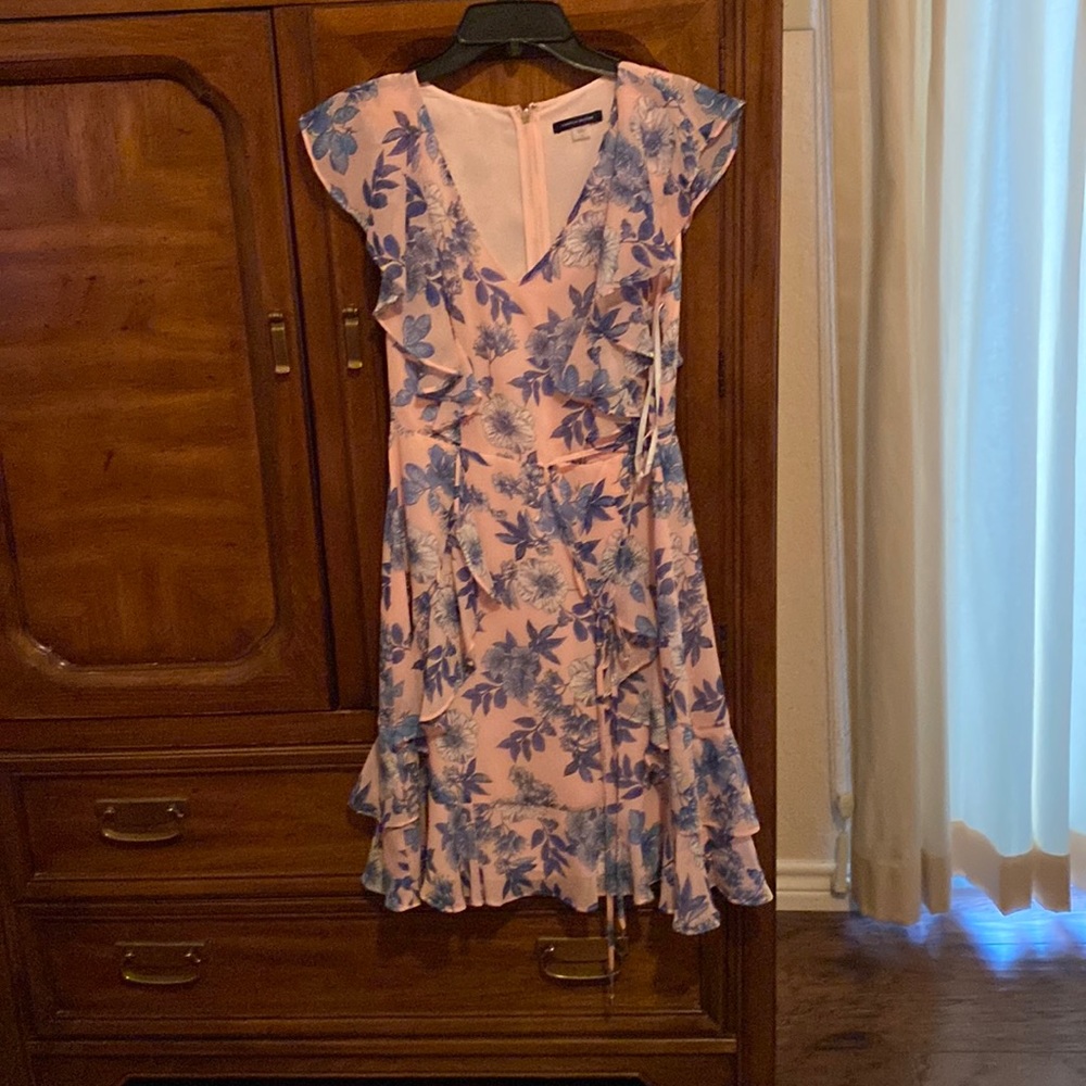 Floral print pink background with blue floral flowers. Zips in back .